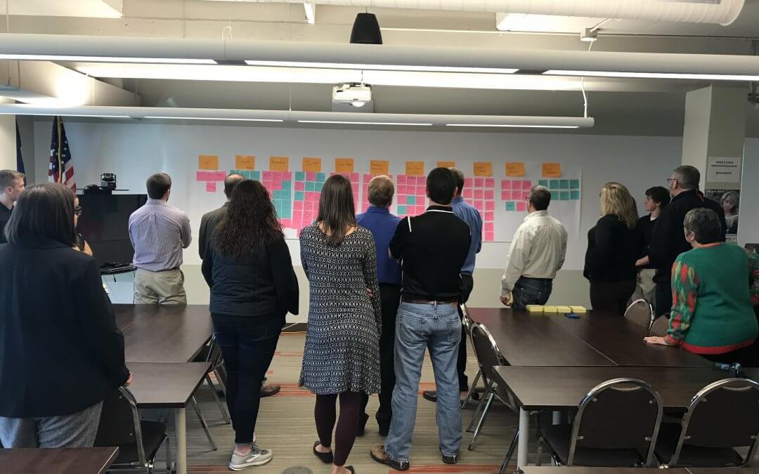 teachers face a project board with sticky notes on the wall